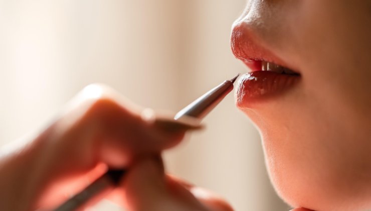 Donna applica matita labbra