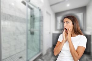 doccia in bagno e donna sorpresa con mani in faccia