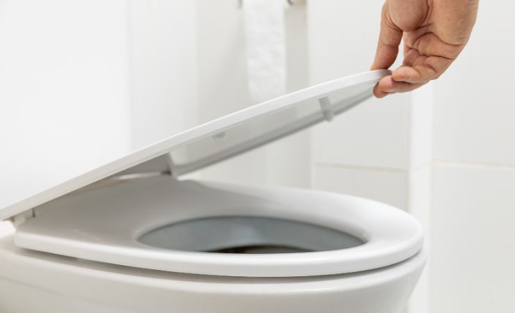 donna che chiude tavoletta wc 