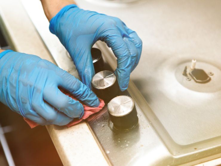 persona che pulisce piano cottura