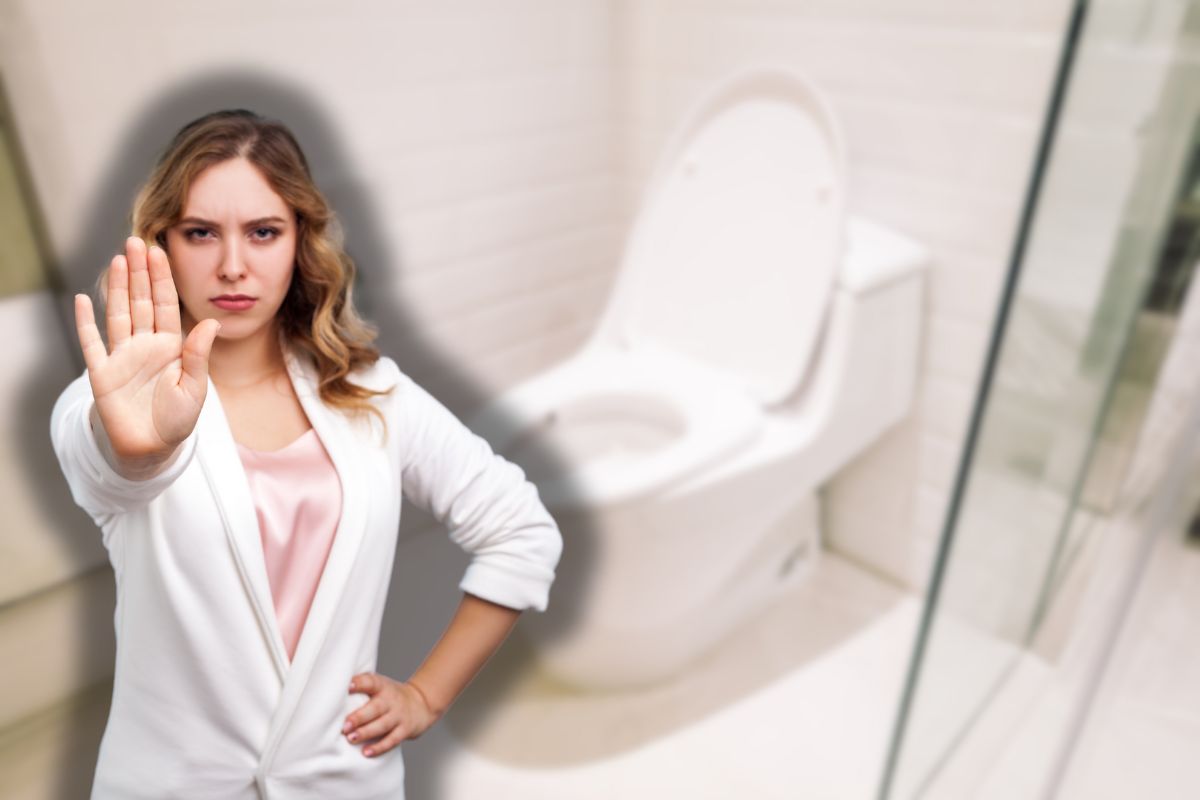 wc con tavoletta alzata e donna che fa stop con le mani